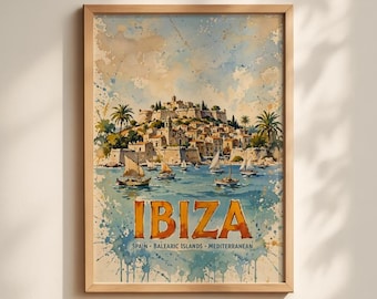May include: A framed watercolor print featuring a coastal town on a hill overlooking a blue sea with sailboats. The text IBIZA is printed in large orange letters, with SPAIN BALEARIC ISLANDS MEDITERRANEAN written below in smaller font.