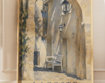 May include: A vertical wall art print in a light wood frame depicting a stone archway in Lacoste, Provence, France. The scene features a white bench, two wall-mounted lanterns, and textured stone walls. The text reads LACOSTE LUBERON PROVENCE FRANCE.