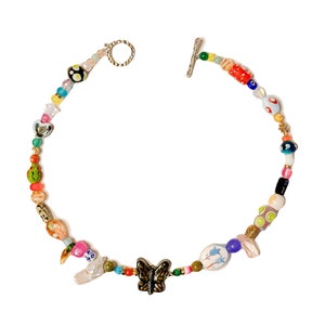 May include: A colorful beaded necklace with a butterfly charm. The necklace features a variety of beads in different shapes, sizes, and colors, including red, green, blue, and yellow. The clasp is silver-toned.