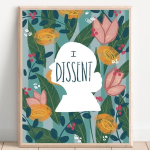 May include: Framed art print featuring a white silhouette of a person's profile with the words "I DISSENT" in black. The background is a teal floral pattern with orange and pink flowers and green leaves. The print is in a light wood frame.