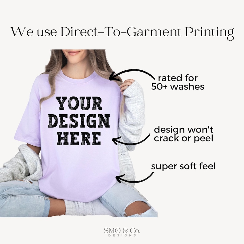 Op de afbeelding: Een lichtpaars t-shirt met de tekst "YOUR DESIGN HERE" in vette zwarte letters. Het shirt is geschikt voor meer dan 50 wasbeurten, met een ontwerp dat niet scheurt of loslaat en een superzacht gevoel heeft. De afbeelding bevat ook de tekst "We use Direct-To-Garment Printing".