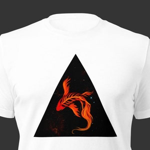 Pode incluir: Uma camiseta branca com um design de triângulo preto que apresenta um peixe estilizado laranja e vermelho sobre um fundo preto estrelado.