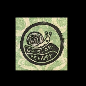 Könnte beinhalten: Schwarz-weiß-Illustration einer Schnecke mit dem Text "Go Slow Be Happy" in einem Kreis.