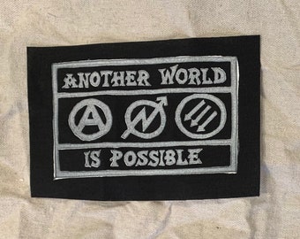 Parche "Otro mundo es posible": Parche de linograbado hecho a mano