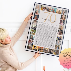 May include: A framed print with a collage of photos and text, held by a person. The print features the number "70" in gold, the words "seventy" and "REASONS WE LOVE YOU". The print is surrounded by a black frame.