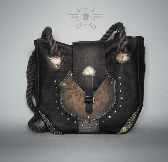 A shopper / shoulder or hand bag inspired by the gothic style. Decorated with golden inserts, rivets and ornaments.