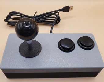 May include: A gray and black USB arcade joystick with a black ball top and two black buttons.