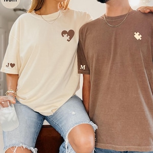 A woman and a man are standing close together, smiling and posing for a photo.
