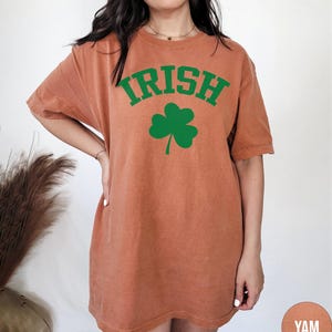 a woman wearing an irish t - shirt with a shamrock on it