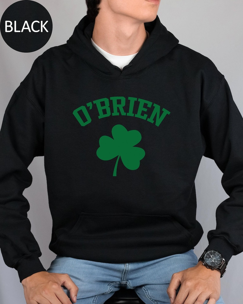 a man wearing a black hoodie with a shamrock on it