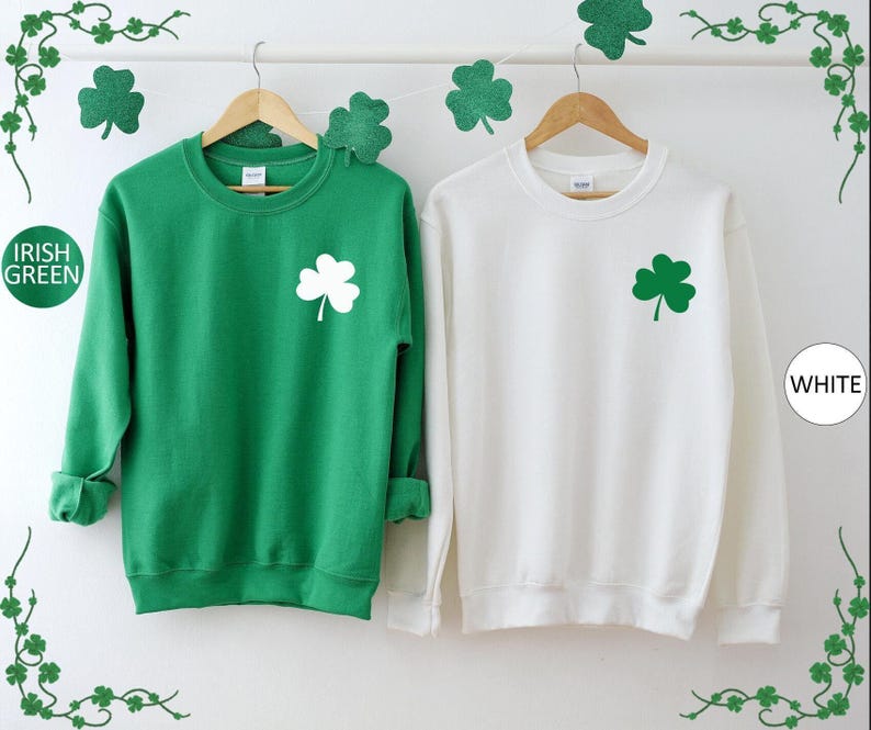 two green and white sweatshirts hanging on a wall