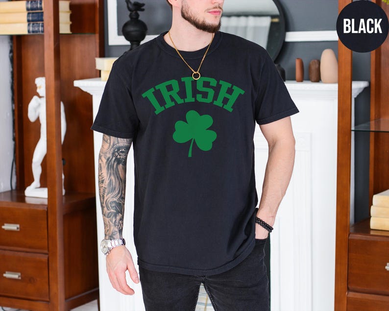 a man wearing a black shirt with a shamrock on it