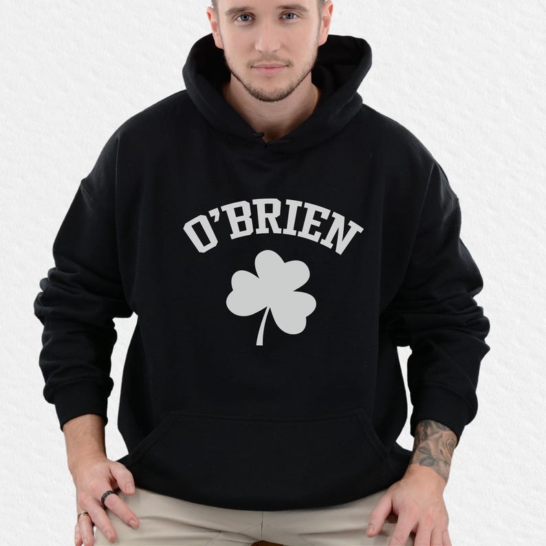A man wearing a black hoodie with the name "O'Brien" and a white clover graphic on it.