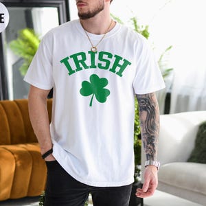 a man wearing a white shirt with a shamrock on it