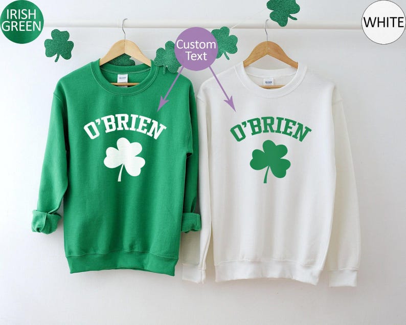 two green and white sweatshirts hanging on a clothes line