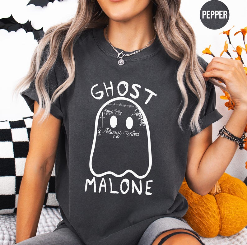 A person wearing a black t-shirt with a graphic of a ghost and the text "GHOST MALONE" printed on it.