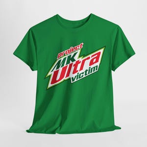 Könnte beinhalten: Grünes T-Shirt mit einer weißen und roten Grafik, auf der "project MK Ultra victim" steht.