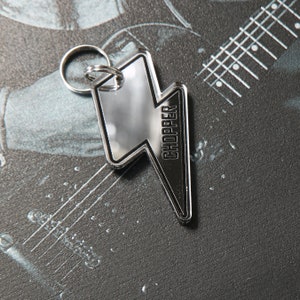 May include: A silver lightning bolt keychain with the word "CHOPPER" printed on it.