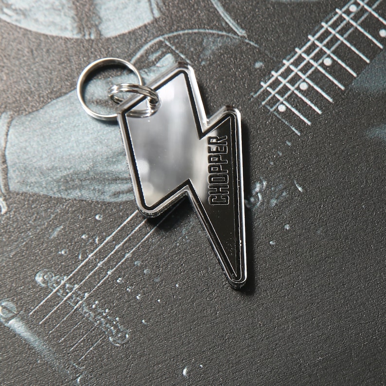May include: A silver lightning bolt keychain with the word "CHOPPER" printed on it.