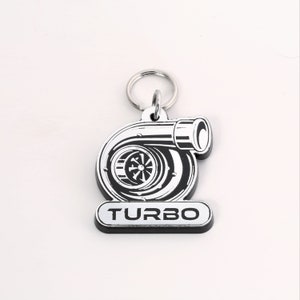May include: A silver and black turbocharger keychain with the word "TURBO" printed on the bottom.