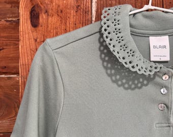 Light Green Top Featuring a Decorative Cut Out Floral Collar