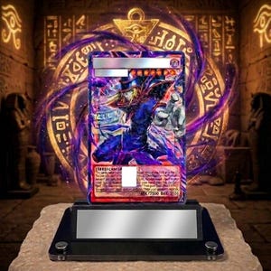 May include: A collectible trading card featuring a character in a blue and purple outfit, displayed on a black stand atop a stone base. The card has a silver border and is set against a background of ancient Egyptian-style hieroglyphs.
