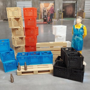 Puede incluir: Una colección de cajas en miniatura en varios colores, incluyendo beige, naranja, azul, blanco y negro. Las cajas están apiladas y dispuestas con pequeñas paletas de madera y botellas en miniatura. Una figura de una persona con camisa amarilla y delantal azul está cerca.