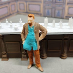 Peut inclure: Figurine miniature d'un homme en manteau marron et gilet bleu devant un bar. Le bar est marron avec un comptoir blanc et plusieurs bouteilles blanches. L'arrière-plan présente un bar et un mur assortis.