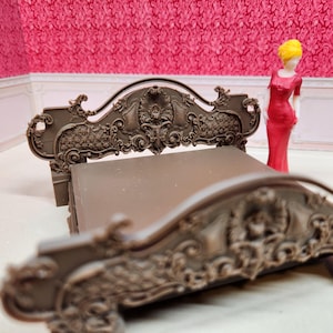 May include: A miniature brown bed with ornate carvings and a matching headboard. A small figurine in a red dress and yellow hair stands next to the bed. The bed is set against a pink floral patterned backdrop.