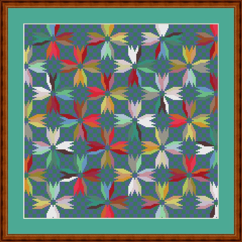 May include: A cross-stitch pattern featuring a repeating floral motif in shades of red, yellow, white, and green against a dark blue background. The design is enclosed within a white border and a thick, textured brown wooden frame.