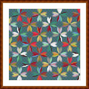 May include: A framed cross-stitch pattern featuring a repeating floral motif on a dark teal background. The design consists of interconnected four-petaled flowers in various colors including red, yellow, white, light green, and pink.