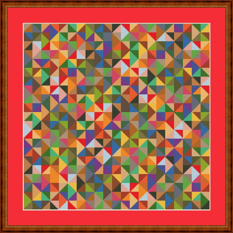 May include: A framed cross-stitch artwork with a geometric pattern of colourful triangles. The design uses a wide array of colours, including red, orange, yellow, green, blue, and purple. The artwork is set against a red border and framed in a brown wooden frame.