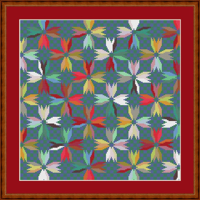 May include: A cross-stitch pattern featuring a repeating grid of multi-coloured floral shapes on a dark teal background. The design consists of symmetrical petals in shades of red, yellow, white, and green, enclosed within a deep red border and a wooden frame.