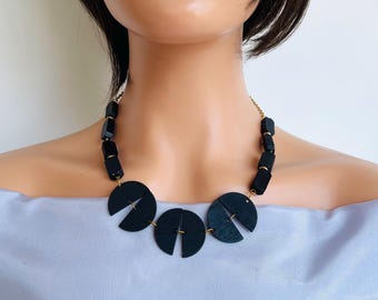 Colar statement com contas de madeira preta e corrente dourada, estilo boho-hippie.