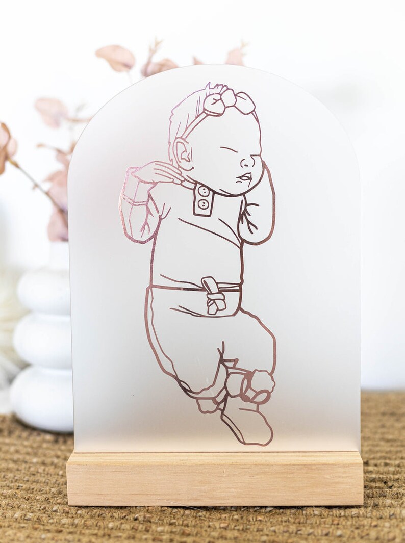 Evelet Designs Grand size acrylic perspex arch. Custom portrait of your baby illustrated and cut from your colour choice of vinyl. Pine or merbau base. You have the choice of colour for the background.

Frosted acrylic with rose gold mirror vinyl.