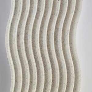 May include: A white, textured, wavy surface with a speckled pattern. The surface is approximately 5 inches wide and 18 inches long.