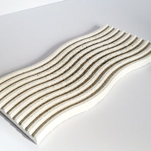 May include: White wavy tray with a textured surface. The tray is made of concrete and has a modern design.