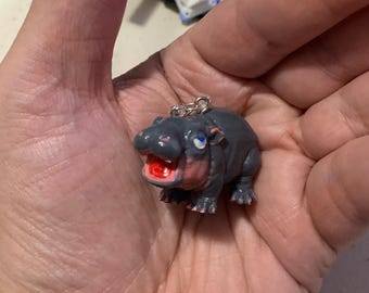 3D printed chubby Moo Deng earrings.
