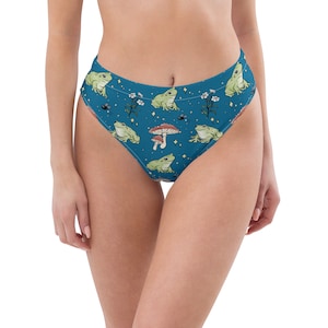 May include: High-waisted blue bikini bottoms featuring a pattern of green frogs, mushrooms, and white flowers. These bottoms offer a comfortable fit, ideal for swimming or sunbathing.