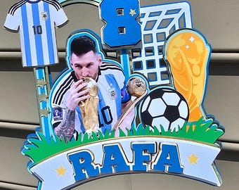 May include: A blue and white soccer jersey with the number 10 on it, a blue number 8, a soccer ball, a gold trophy, a soccer goal, and a green grass field. The words "RAFA" are on a blue banner with gold stars.