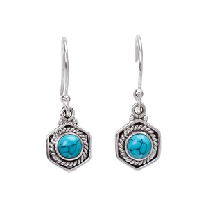 May include: A pair of silver-toned drop earrings. Each earring features a hexagonal frame with a turquoise stone center. The frame has a rope-like border. The earrings have a simple hook closure.