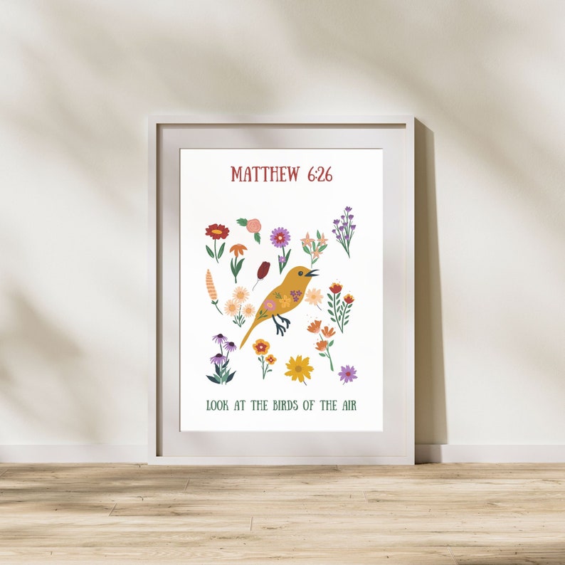 May include: A framed art print with a yellow bird illustration and floral elements. The text "Matthew 6:26" is at the top, with "Look at the birds of the air" at the bottom. The print is in a white frame, suitable for home decor.
