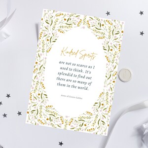 May include: A white card with the text "Kindred Spirits" in gold script, surrounded by a floral border of green leaves and pink and yellow flowers. The quote is from Anne of Green Gables.