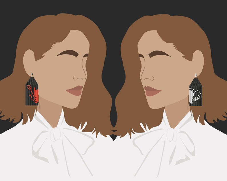 May include: A woman with brown hair is wearing a white shirt with a bow tie. She is wearing a pair of black earrings with red and white embroidered designs. The earrings are shaped like a rectangle.