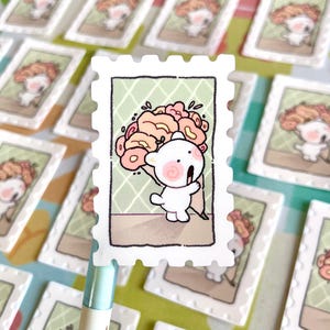 May include: A white bear holding a bouquet of pink and orange flowers. The bear is smiling and has a pink blush on its cheeks. The image is framed with a white border and looks like a vintage postcard.