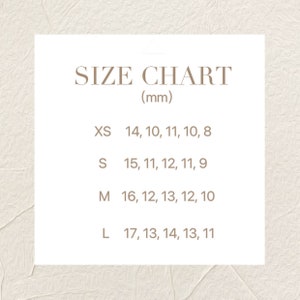 May include: A size chart for a product with measurements in millimeters. The chart lists sizes XS, S, M, and L with corresponding measurements for five different dimensions.