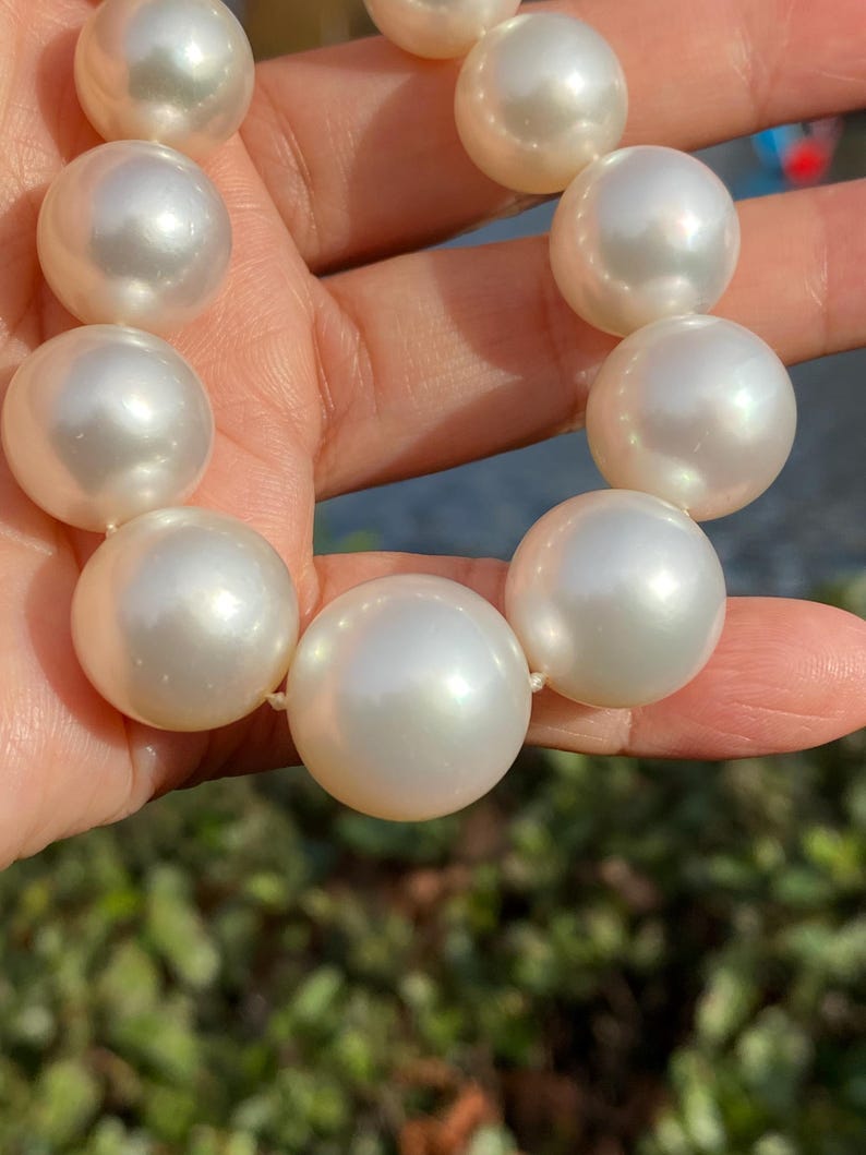 Pode incluir: Um colar de p&eacute;rolas grandes, brancas e cremosas. As p&eacute;rolas s&atilde;o esf&eacute;ricas e t&ecirc;m um brilho brilhante. As p&eacute;rolas s&atilde;o enfiadas, possivelmente formando um colar ou uma pulseira.