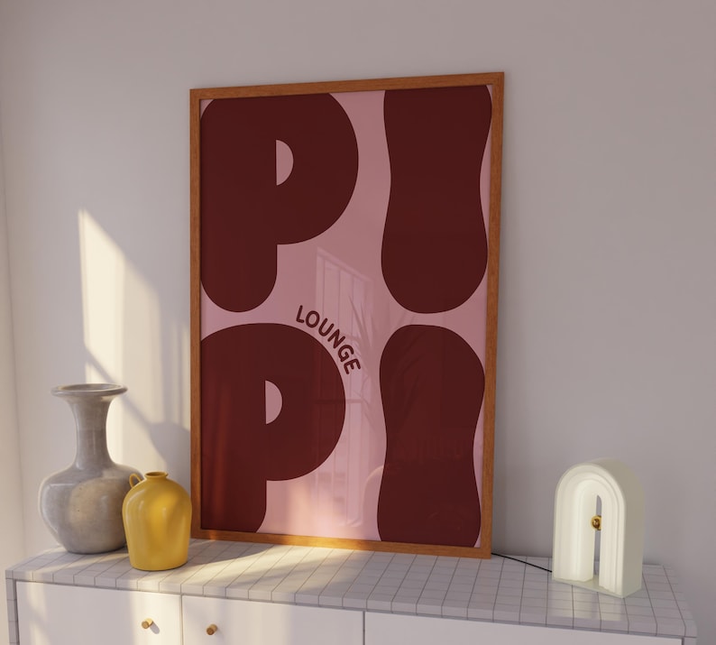 Pu&ograve; includere: Una stampa incorniciata con sfondo rosa e la parola "P.I.P.I. LOUNGE" in grandi lettere rosse stilizzate.