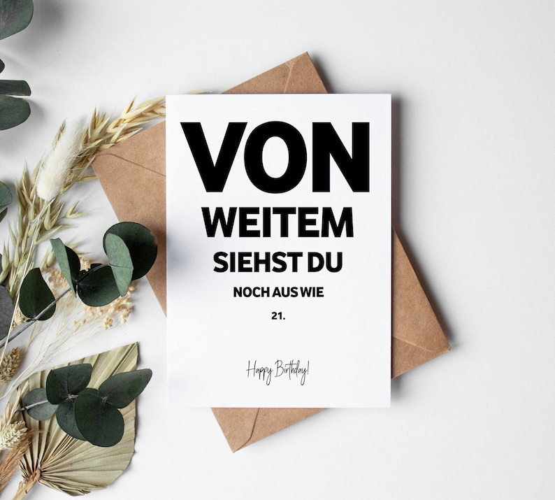 May include: A white card with black text that reads "Von Weitem Siehst Du Noch Aus Wie 21. Happy Birthday!"