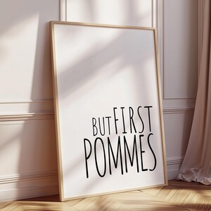 Może przedstawiać: Wydruk w ramie z białym tłem i czarnym tekstem, kt&oacute;ry brzmi "But first, pommes".
